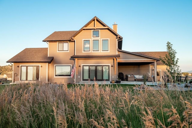 rear view of house with a chimney, an outdoor hangout area, and a patio