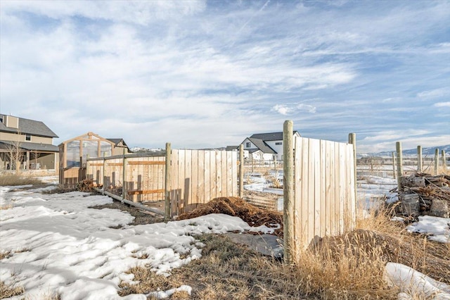 yard covered in snow with an outdoor structure and fence