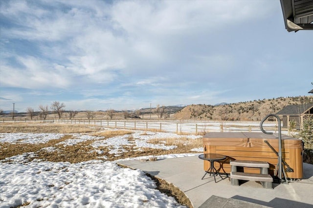 yard covered in snow featuring a patio, fence, and a hot tub