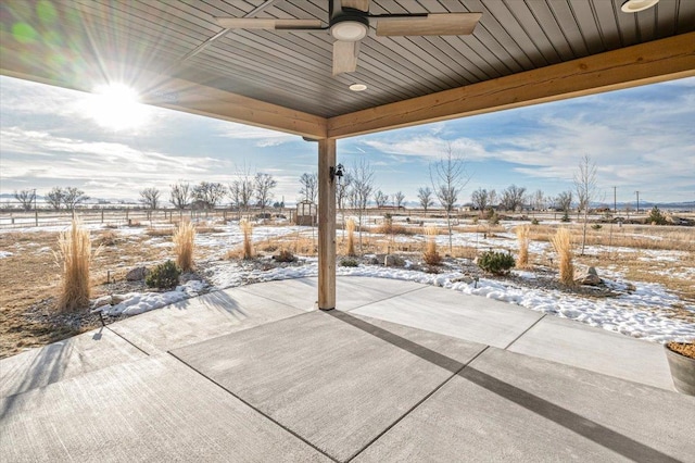 snow covered patio with fence and a ceiling fan