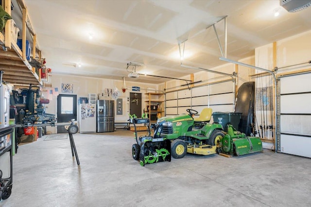 garage featuring electric panel, stainless steel fridge with ice dispenser, a garage door opener, and freestanding refrigerator