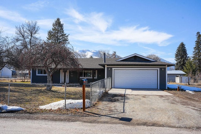 ranch-style home with a garage, driveway, and a fenced front yard