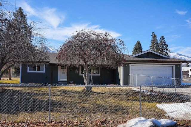 ranch-style house with a garage, driveway, a fenced front yard, and roof with shingles