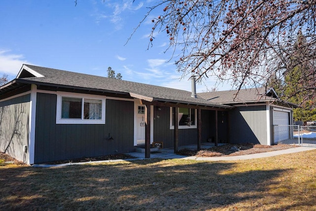 ranch-style home featuring an attached garage, fence, and a front lawn