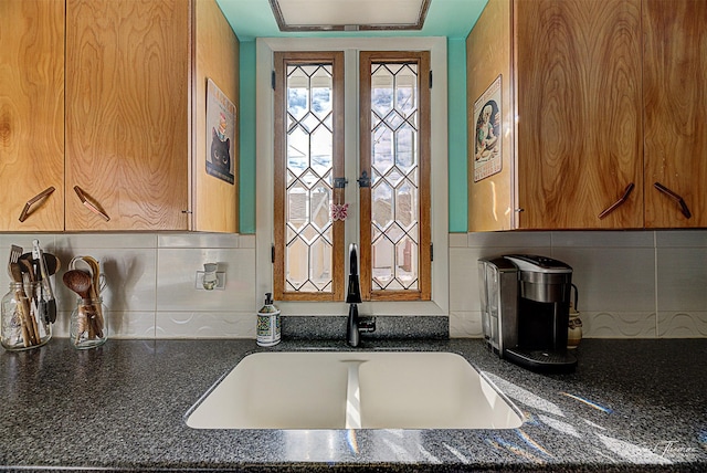 interior space with brown cabinetry, french doors, a sink, and backsplash