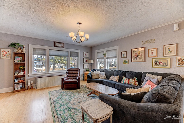 living area with a textured wall, radiator, ornamental molding, hardwood / wood-style floors, and a chandelier