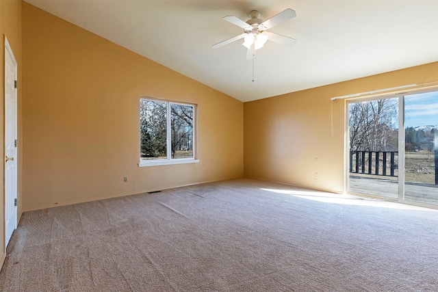 unfurnished room with visible vents, a ceiling fan, vaulted ceiling, and carpet flooring