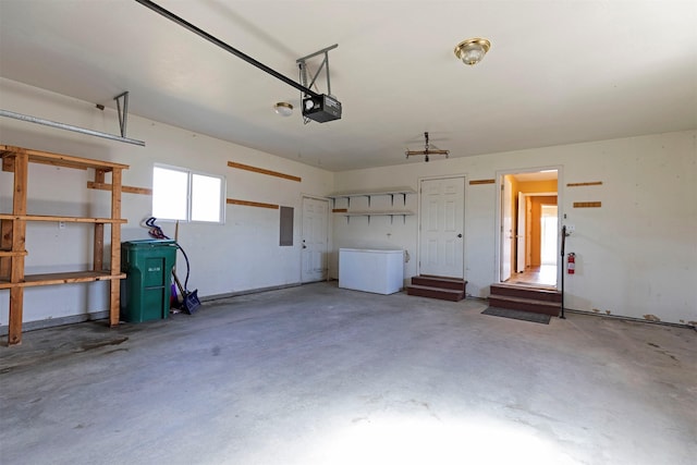 garage with a garage door opener and electric panel