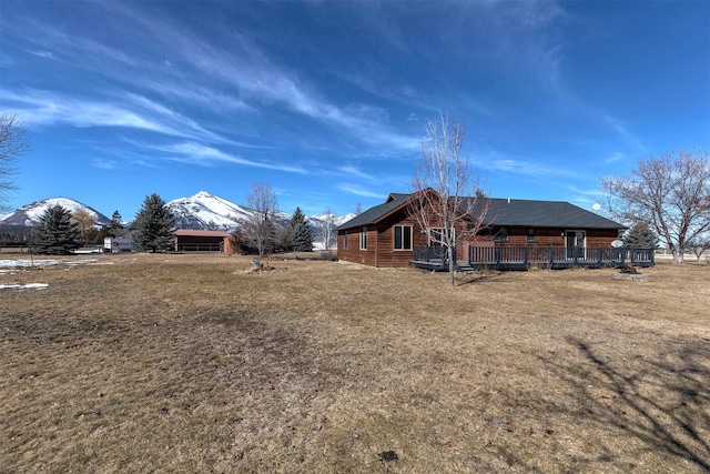 back of house with a yard and a mountain view