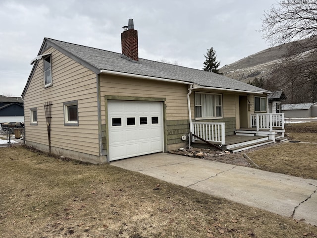 single story home featuring a shingled roof, concrete driveway, a chimney, and an attached garage