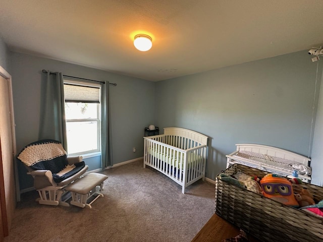 bedroom featuring a nursery area, carpet floors, and baseboards