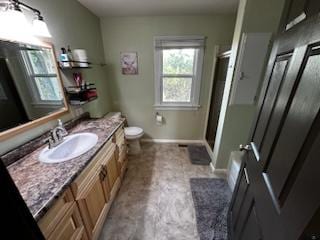 full bath with toilet, a shower stall, vanity, and baseboards