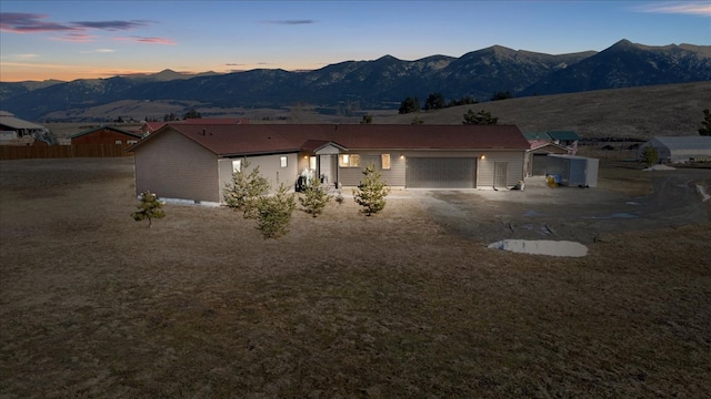 ranch-style house featuring a garage, driveway, and a mountain view