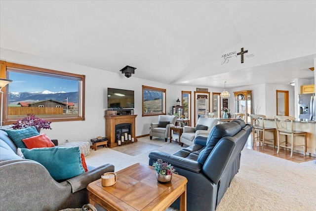 living room with vaulted ceiling, a fireplace, and baseboards