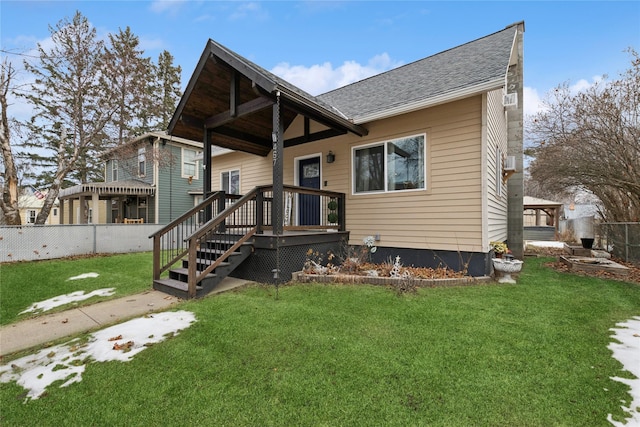 view of front of home featuring a front lawn, roof with shingles, and fence