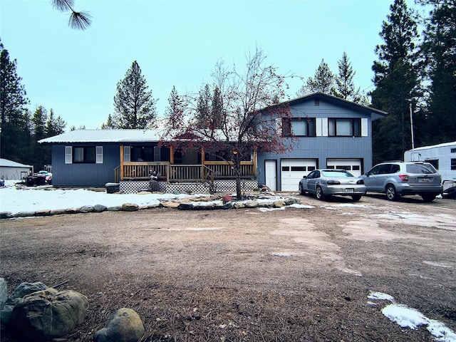 view of front of property featuring driveway, covered porch, and an attached garage