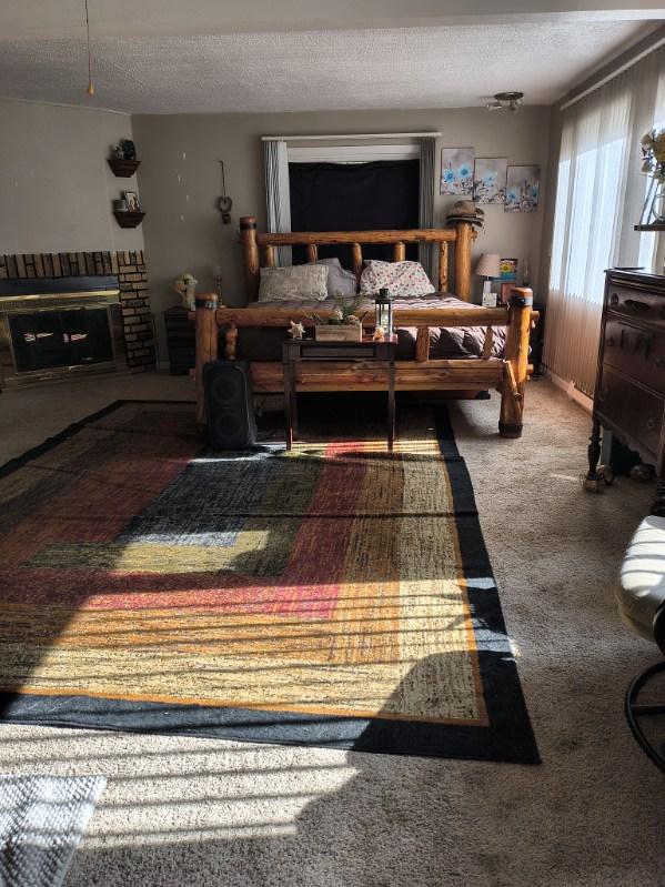 bedroom featuring a textured ceiling, carpet, and a brick fireplace