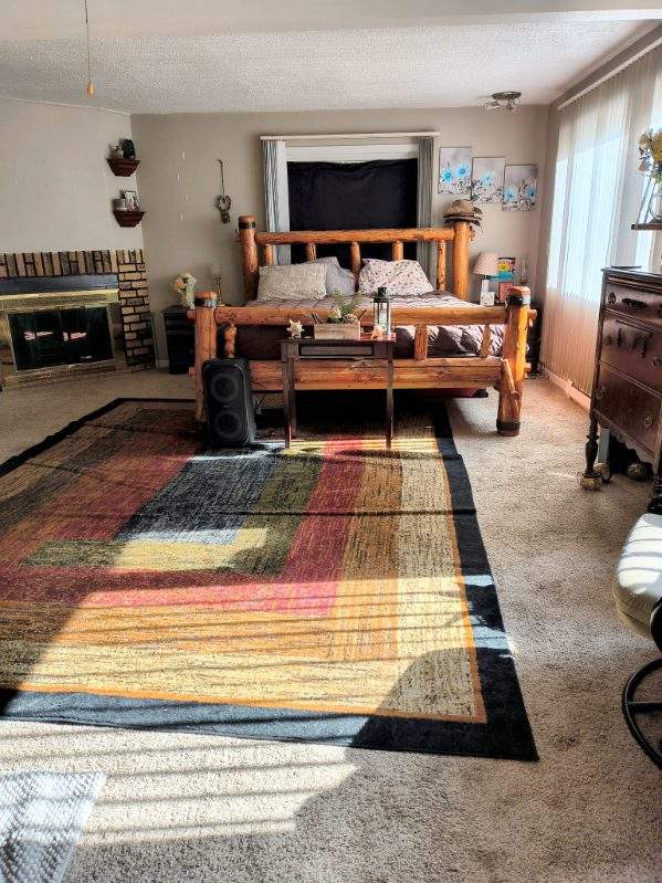 bedroom with a textured ceiling, carpet, and a fireplace