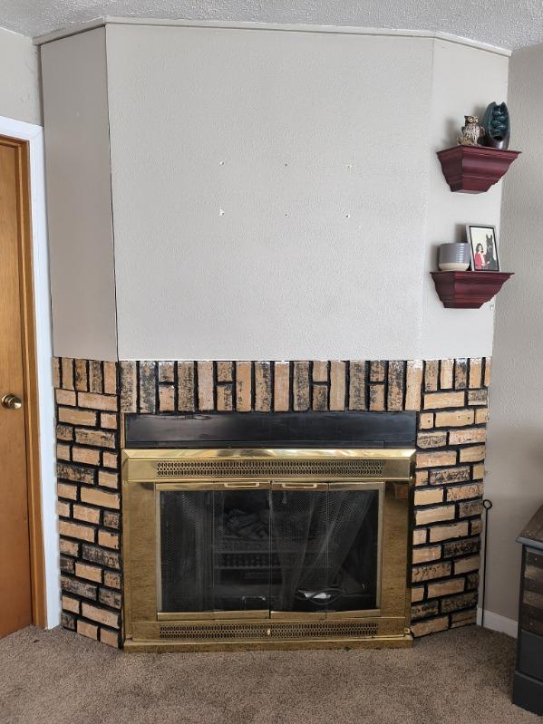 interior details with carpet floors and a glass covered fireplace