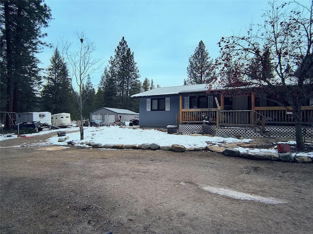 view of front of home with metal roof, a porch, and a detached garage