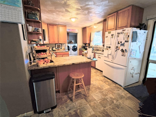 kitchen with a peninsula, separate washer and dryer, a sink, freestanding refrigerator, and open shelves