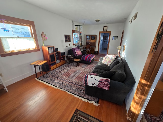 living area with baseboards and wood finished floors