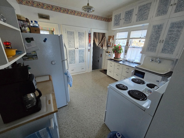 kitchen with visible vents, speckled floor, white appliances, and white cabinetry