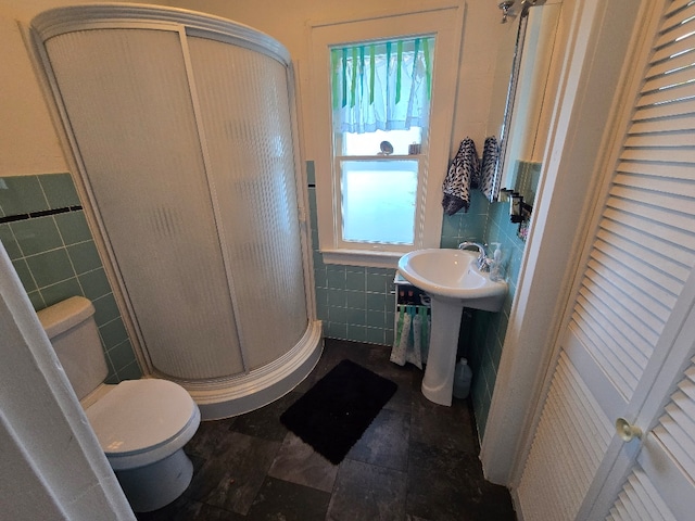 full bath featuring toilet, a stall shower, a closet, and tile walls