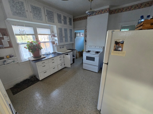 324 1st Ave NW, Choteau, MT 59422 - kitchen featuring white cabinets, white appliances, light speckled floor, and dark countertops
