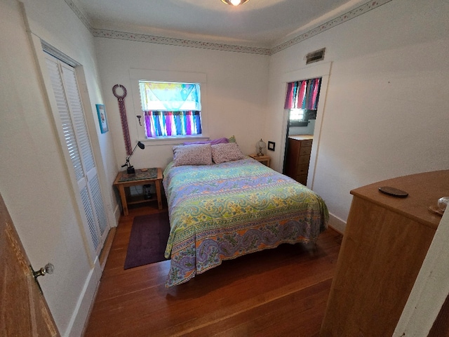 bedroom with crown molding, baseboards, and wood finished floors