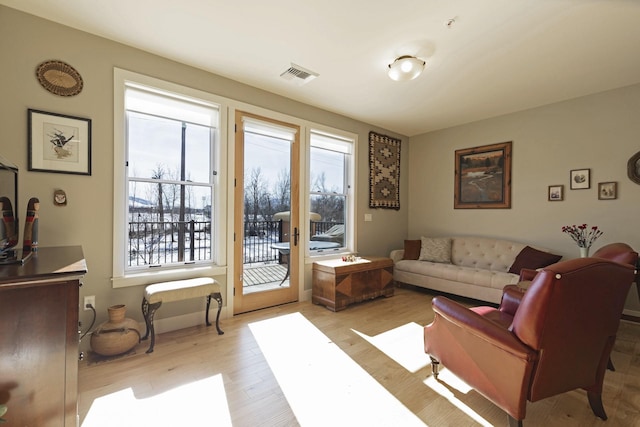 living area featuring visible vents and wood finished floors