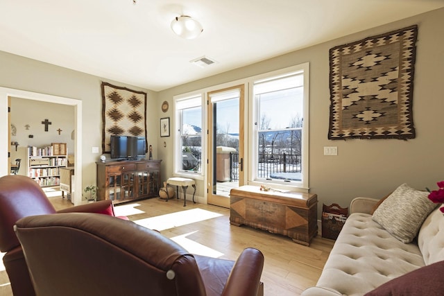 living area with light wood finished floors and visible vents