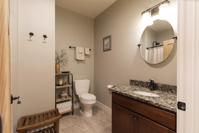 bathroom featuring vanity, toilet, and baseboards