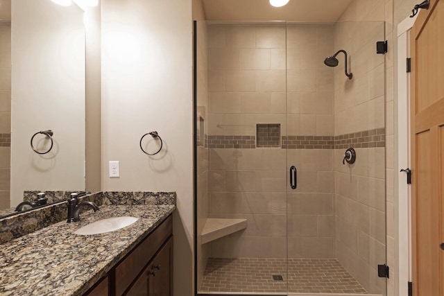 bathroom with a shower stall and vanity