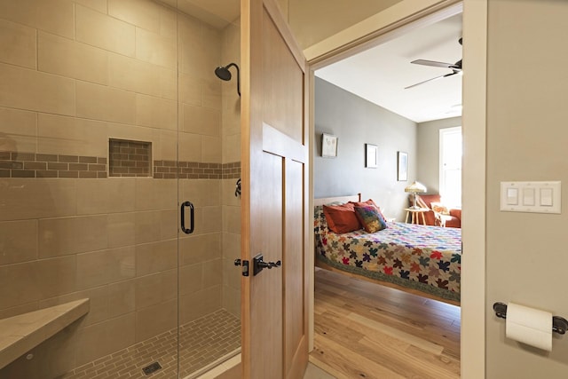 full bath featuring ceiling fan, a stall shower, connected bathroom, and wood finished floors