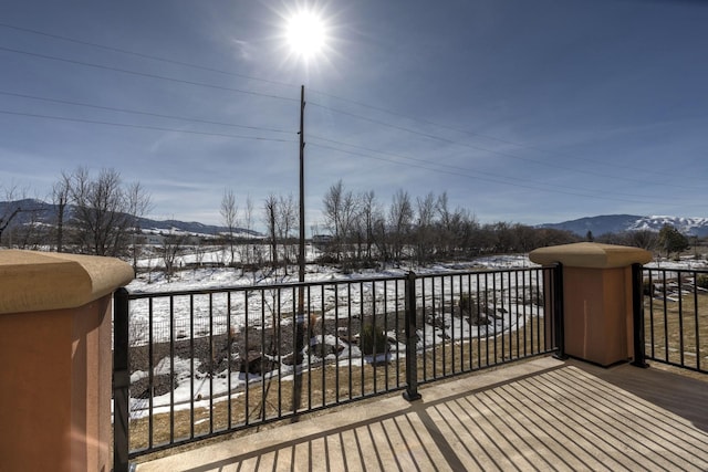 snow covered deck with a mountain view