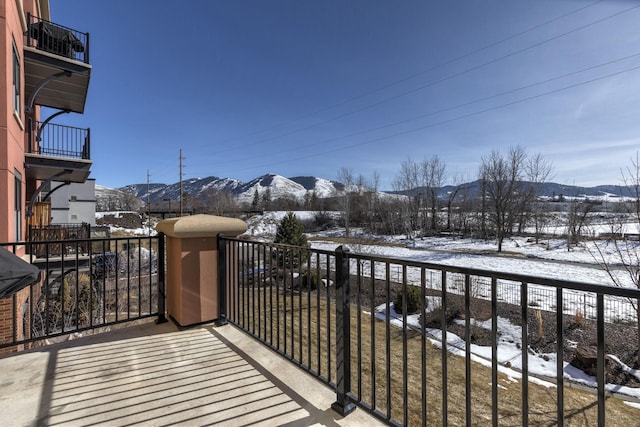 snow covered back of property with a mountain view