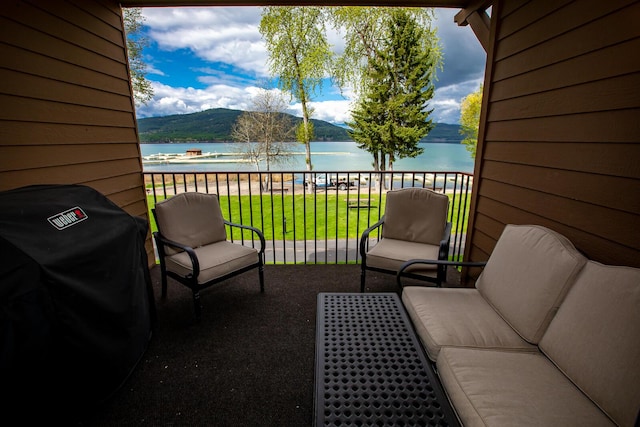 balcony with a water view and area for grilling