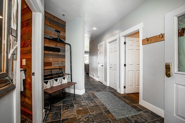 hallway featuring baseboards and stone tile floors