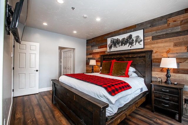 bedroom with recessed lighting, a closet, wood walls, wood finished floors, and baseboards