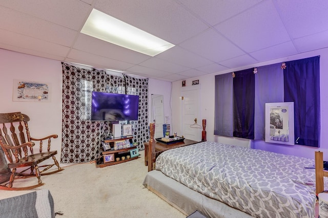 bedroom with carpet floors and a drop ceiling