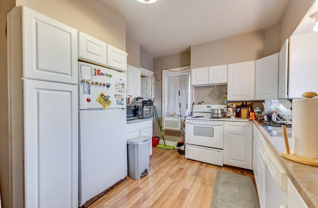 kitchen with white appliances, white cabinets, light wood-style flooring, light countertops, and a sink