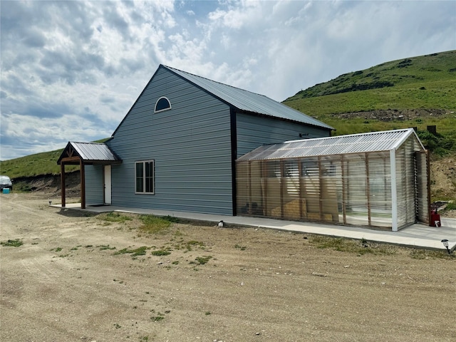 view of home's exterior with metal roof, an outdoor structure, and an exterior structure