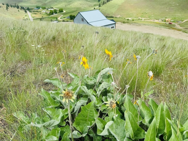 view of outdoor structure featuring a rural view, an outbuilding, and a mountain view