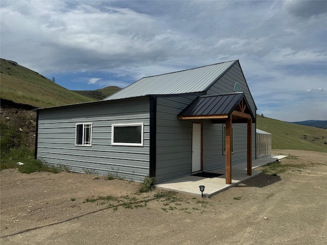 view of side of property with metal roof and a mountain view