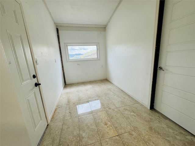 hall featuring light tile patterned floors and baseboards