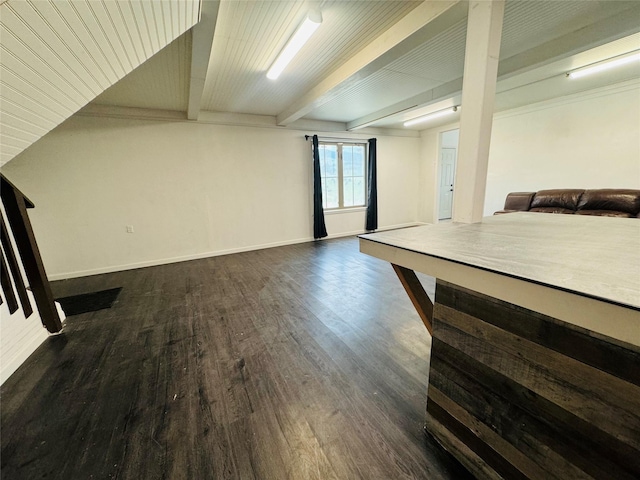 interior space with dark wood finished floors, beam ceiling, and baseboards