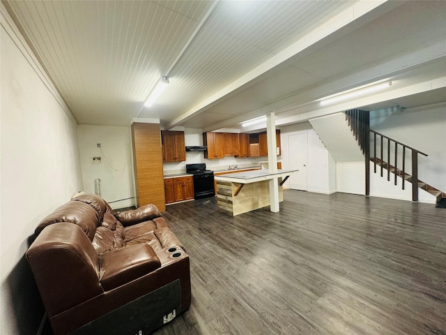 living area with dark wood-style flooring, beam ceiling, and stairs
