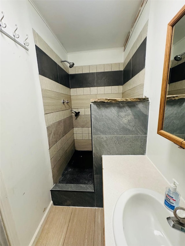 full bathroom with a tile shower and a sink