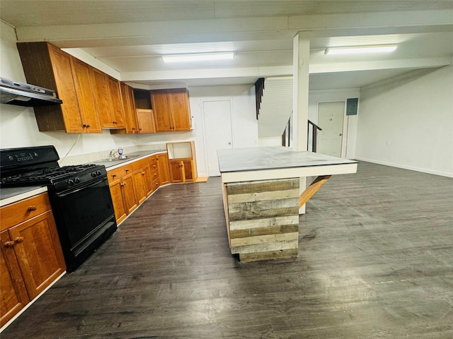 kitchen with black gas stove, dark wood-type flooring, brown cabinets, and light countertops